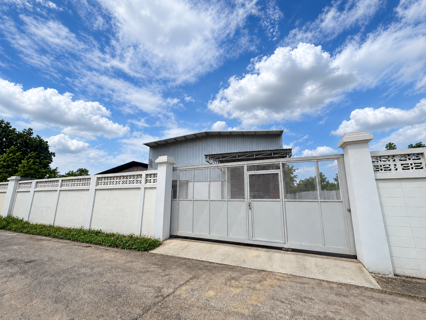 Insulating Asia factory in Samut Sakhon; retouched photograph with the gate closed and overhead utilities removed